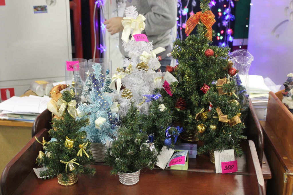 Новогодняя дизайнерская елка, 25 см. украшена колокольчиками, подарками, фруктами, с бантом, подставка-корзинка, 4 цвета в ассортименте, артикул  80389