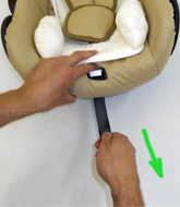После того как вы пристегнули ребенка, необходимо затянуть ремни безопасности, нажав на металлический зажим в основании кресла и потянув за натяжной ремень вниз.